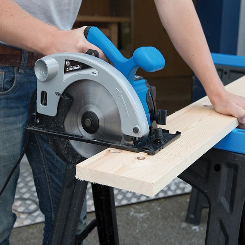 Mesa de trabajo con lápiz y regla, preparando madera para cortes con sierra.