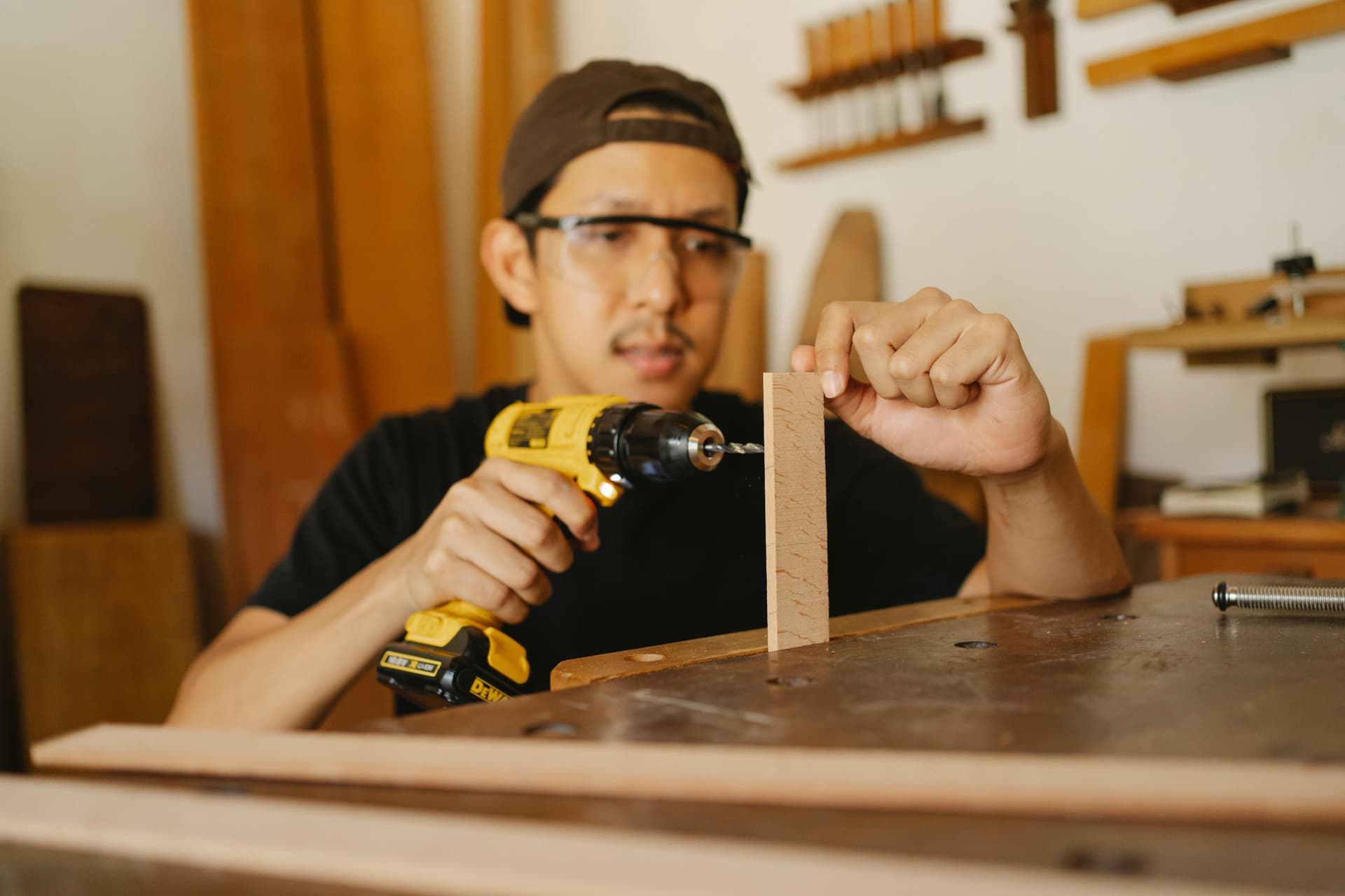 Carpintero midiendo una estructura de madera, utilizando un taladro Dewalt.
