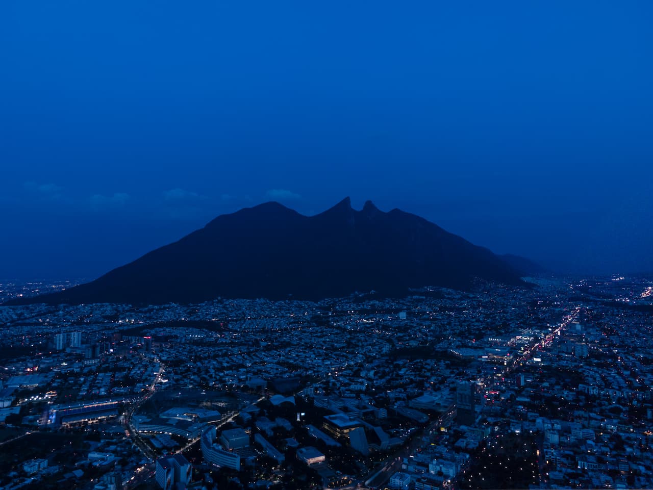 Vista nocturna del Cerro de la Silla en Monterrey, resaltando la ubicación de Ferretería Guevara.