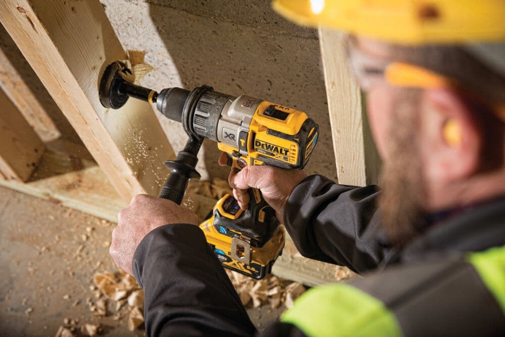 Trabajador utilizando un taladro Dewalt para perforar concreto en una obra.